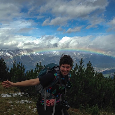 A picture of me in the Alps with a rainbow in the background